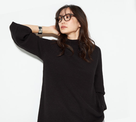 畦編みニットチュニックを着用した女性の写真