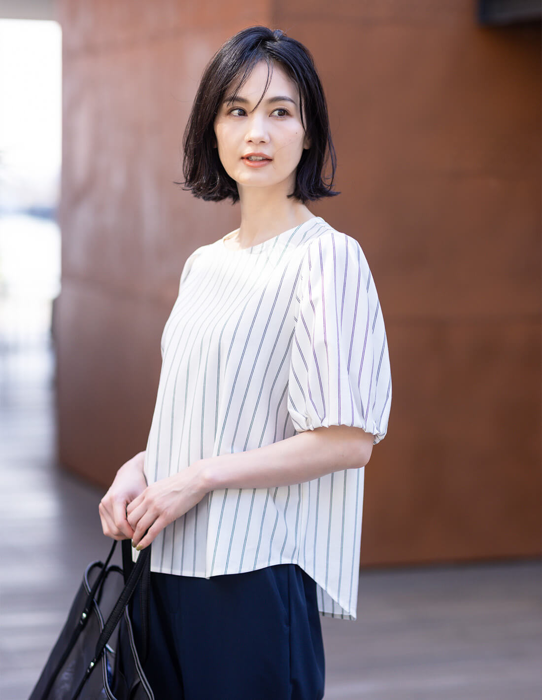 ストライプカットソーブラウスを着用した女性1