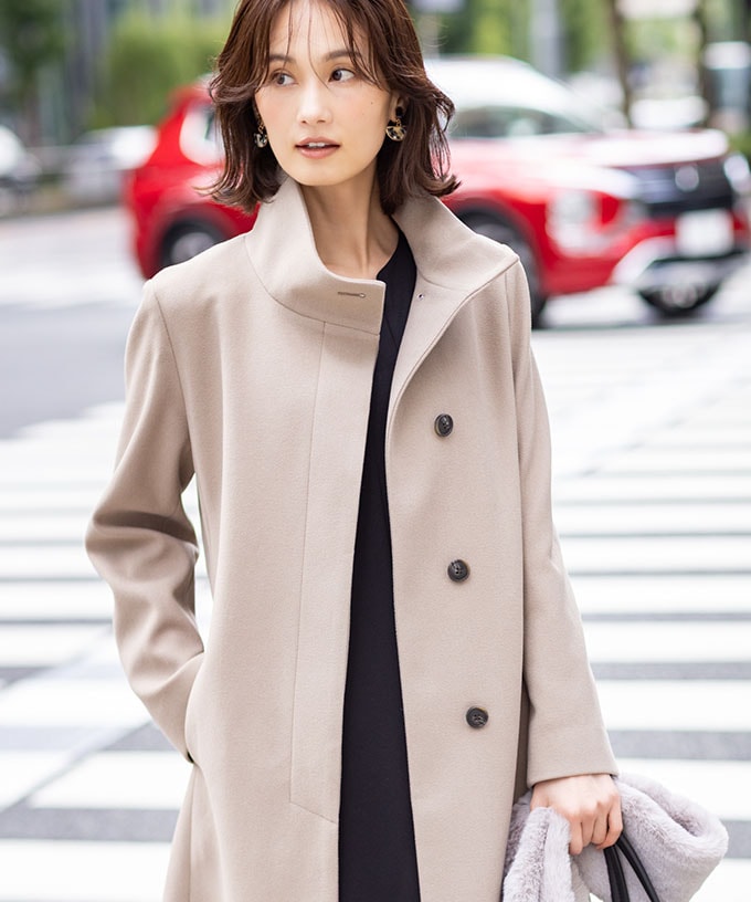 スタンドロングコートを着用した女性２