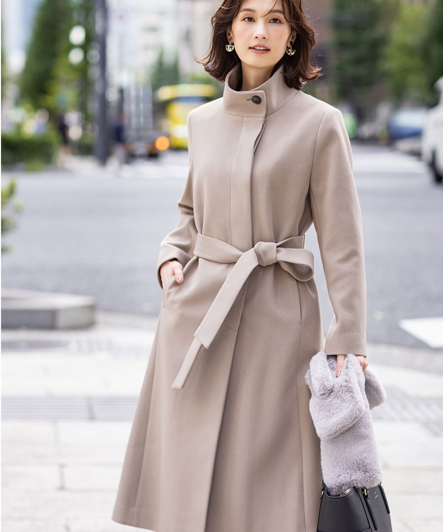 スタンドロングコートを着用した女性３