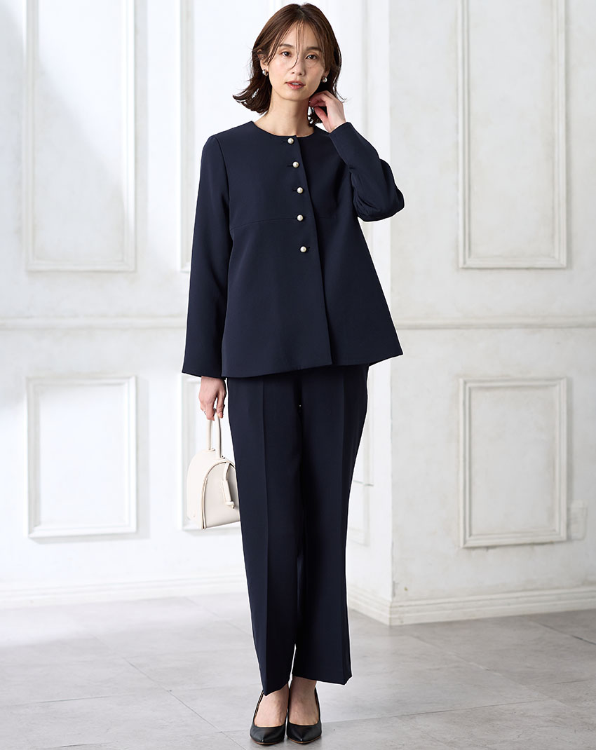 ネイビーのペプラムジャケット【セットアップ対応】・ブラックのストレートパンツ【セットアップ対応】を着用した女性の画像