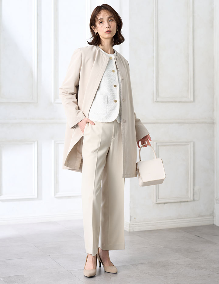 ホワイトのツイードジャケット・アイボリーのストレートパンツ【セットアップ対応】・ホワイトのプリーツTブラウス・アイボリーのスーパーウォームグログランノーカラーコートを着用した女性の画像