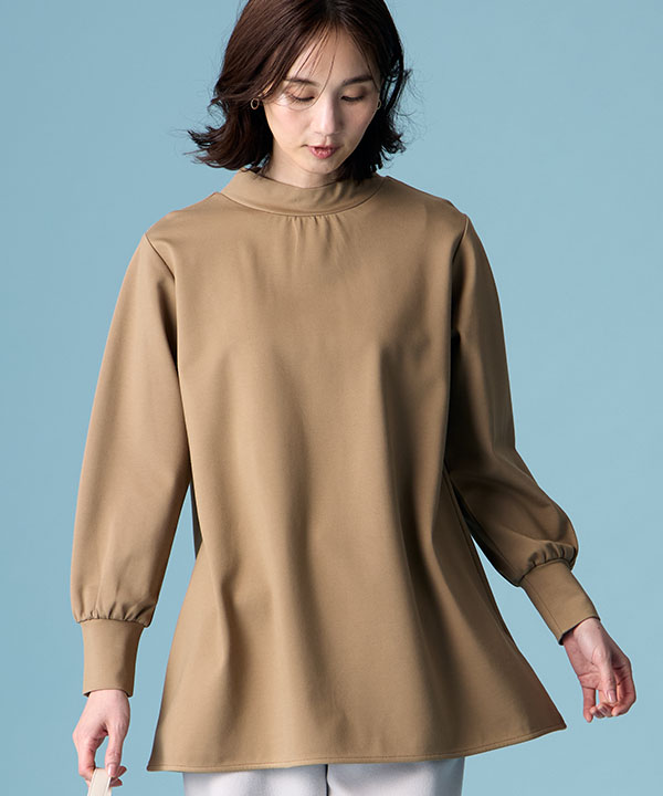 ブラウンのハイネックチュニック・ライトグレーのストレッチ起毛ワイドパンツを着用した女性の画像（アンカーリンク）