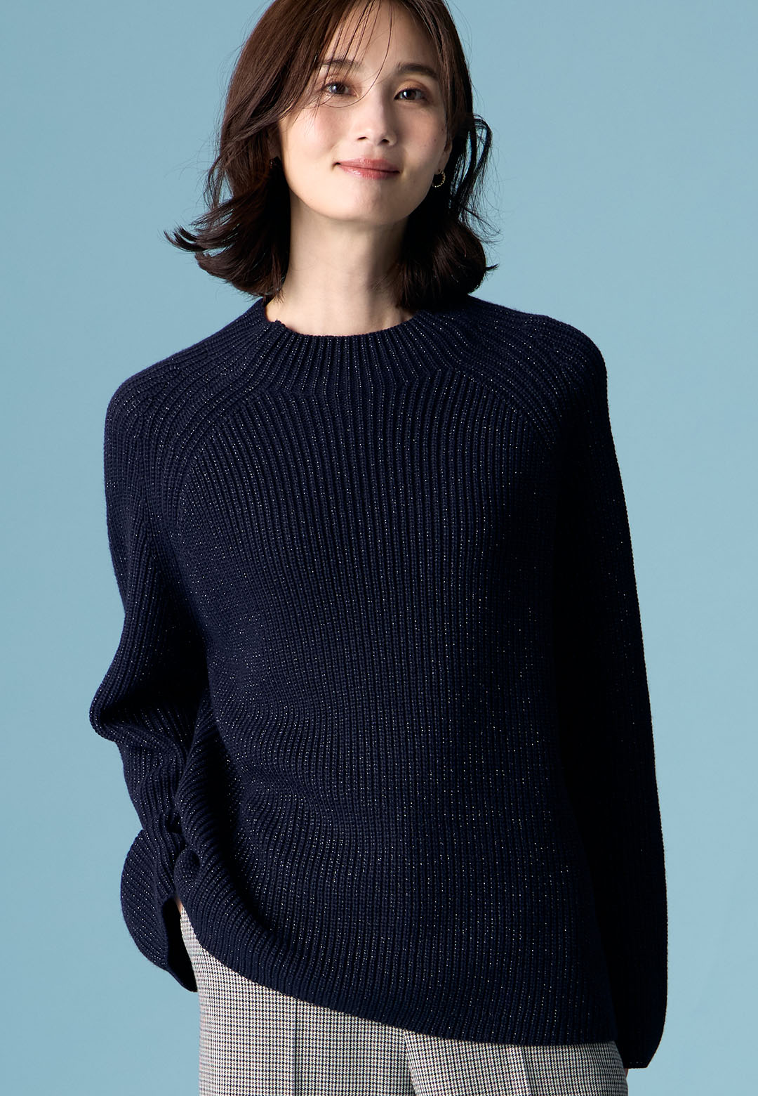 ネイビーのラメニットプルオーバー・ブラックのローズ加工セミワイドパンツを着用した女性の画像