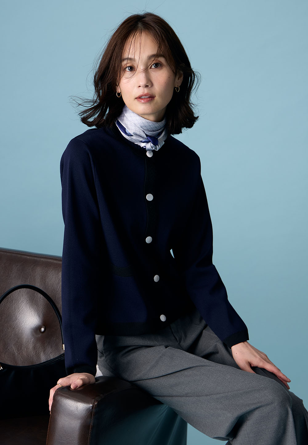 ブラックのバイカラーニットカーディガン・チャコールグレーの【美モーション】ワイドパンツを着用した女性の画像