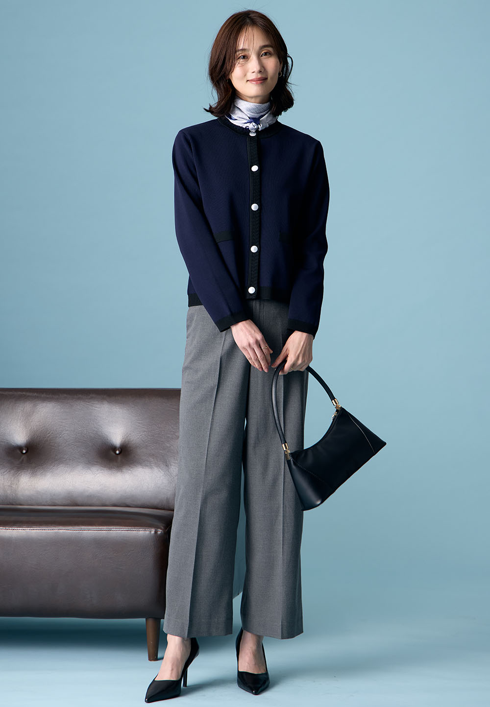 ブラックのバイカラーニットカーディガン・チャコールグレーの【美モーション】ワイドパンツ・ブラックのバッグ・ブラックのパンプスを着用した女性の画像