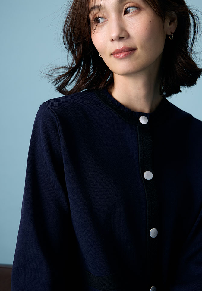 ブラックのバイカラーニットカーディガンを着用した女性のアップの画像