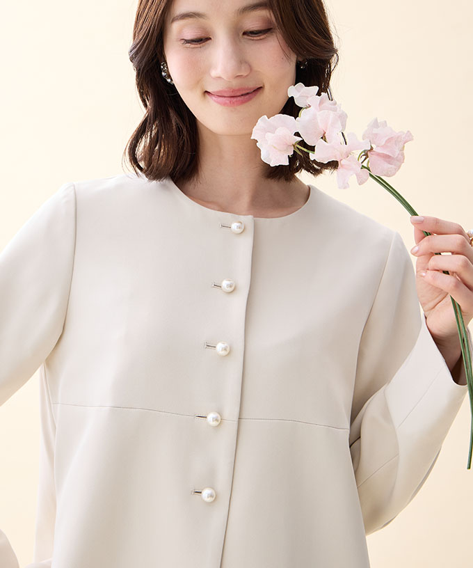 ベージュのペプラムジャケットを着用した女性の画像