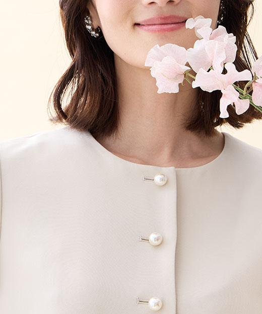 ベージュのペプラムジャケットを着用した女性のアップの画像（ポイント）