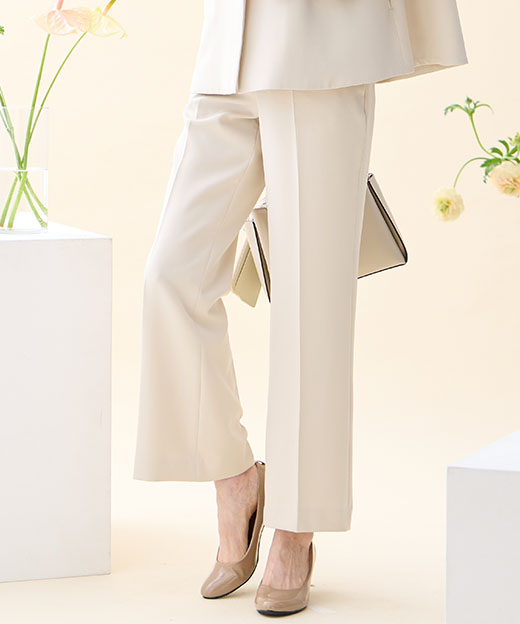 ベージュのペプラムジャケット・ベージュのストレートパンツを着用した女性の足元の画像（ポイント）