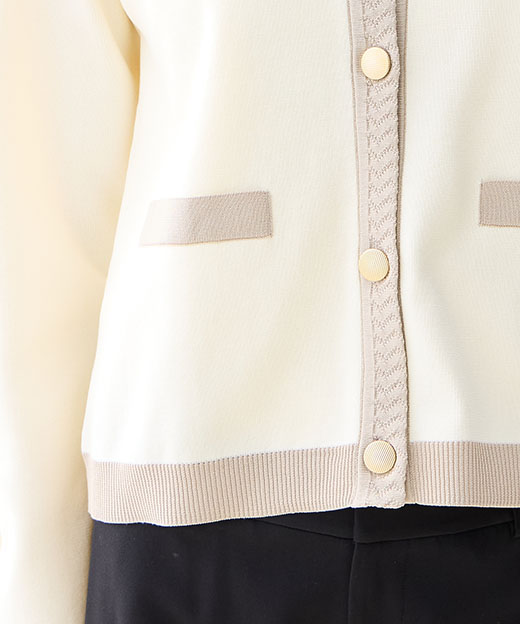 オフホワイトのバイカラーニットカーディガン・ブラックの【アルファブリック】テーパードパンツを着用した女性のアップの画像（ポイント）