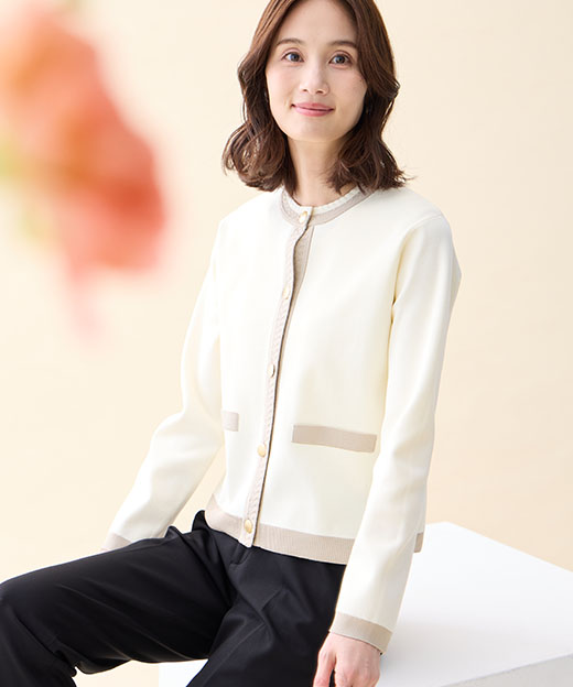 オフホワイトのバイカラーニットカーディガン・ブラックの【アルファブリック】テーパードパンツを着用した女性の画像（ポイント）