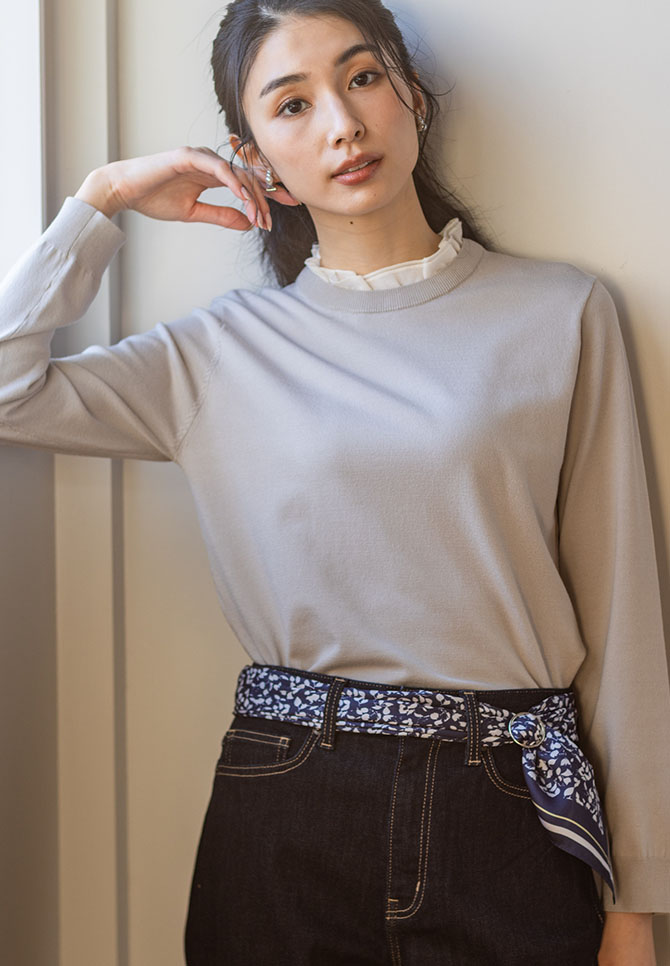 グレージュのフリルカラードッキングプルオーバー・ネイビーのデニムパンツ・ブルーのリング付きスカーフを着用した女性の画像--2