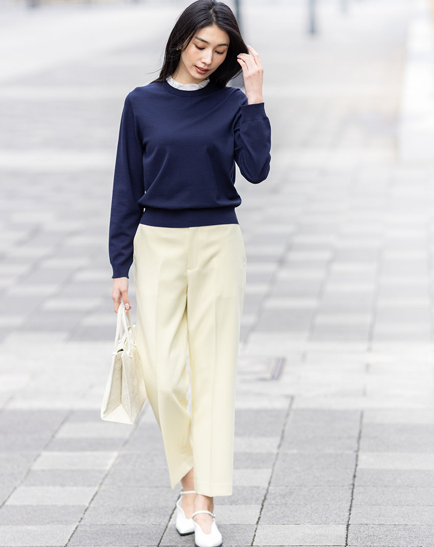 ネイビーのフリルカラードッキングプルオーバー・パステルイエローのストレッチ テーパードパンツを着用した女性の画像--1