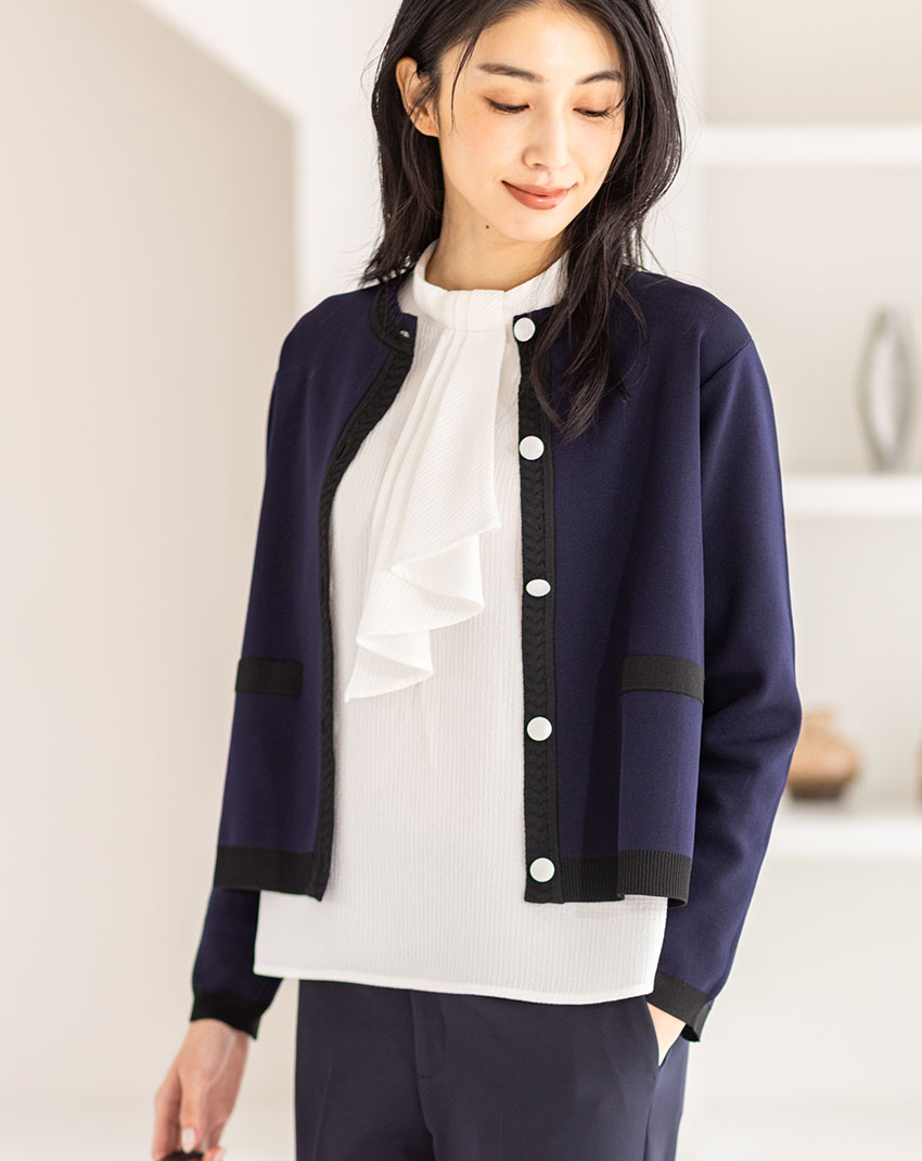 ネイビーのバイカラーニットカーディガン・オフホワイトのジャガードボウタイブラウス・ネイビーのストレッチ テーパードパンツを着用した女性の画像--1
