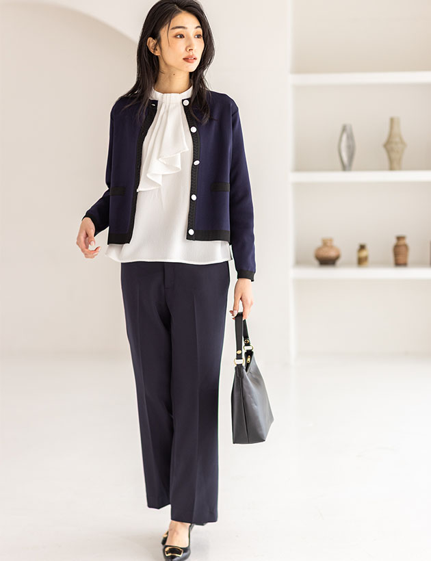 ネイビーのバイカラーニットカーディガン・オフホワイトのジャガードボウタイブラウス・ネイビーのストレッチ テーパードパンツを着用した女性の画像--2