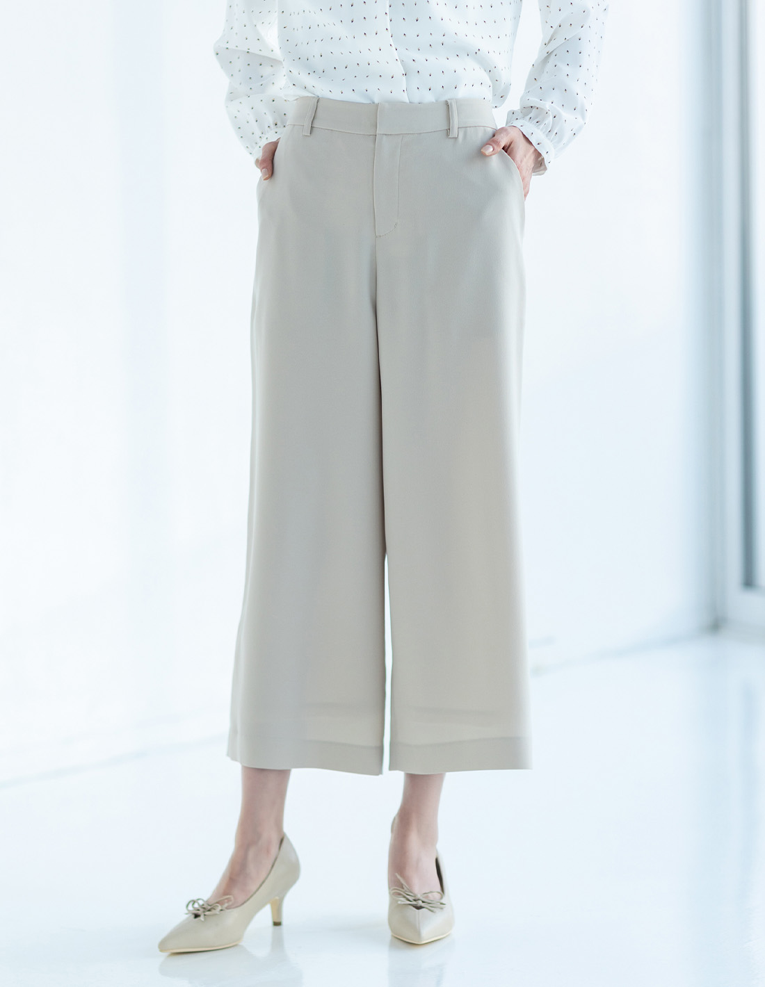 オフホワイトの幾何プリントジョーゼットブラウス・ベージュのストレッチジョーゼットワイドパンツ【セットアップ対応】を着用した女性の足元の画像