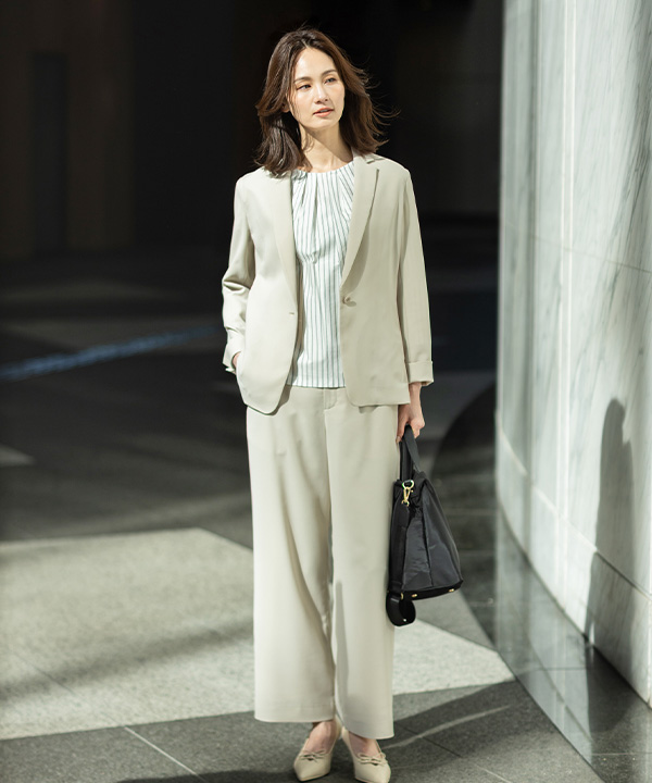 ストレッチジョーゼットテーラードジャケット【セットアップ対応】、ストレッチジョーゼットストレートパンツ【セットアップ対応】、ストライプタックプルオーバーを着用した女性の画像（アンカーリンク）