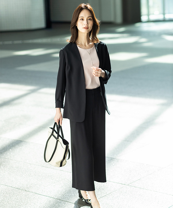 ストレッチジョーゼットカラーレスジャケット【セットアップ対応】、ストレッチジョーゼットワイドパンツ【セットアップ対応】、スムースカットソーを着用した女性の画像（アンカーリンク）