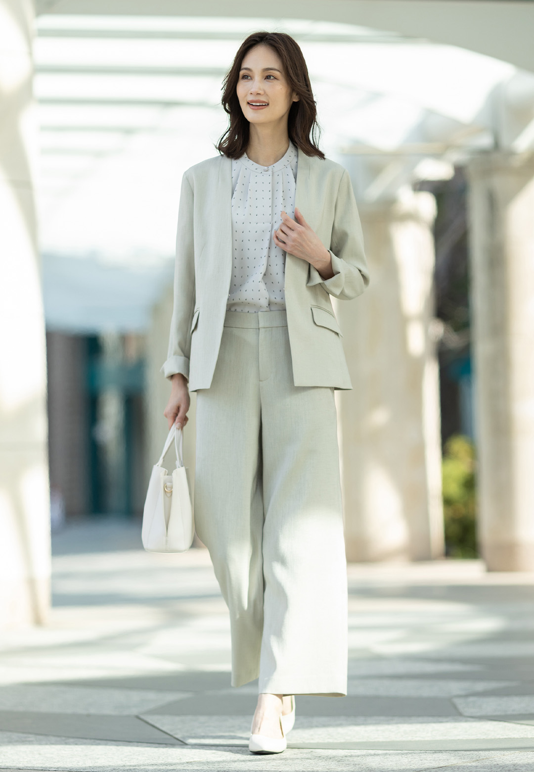 リネンライクカラーレスジャケット【セットアップ対応】、リネンライクワイドパンツ【セットアップ対応】、幾何プリントジョーゼットブラウスを着用した女性のアップの画像