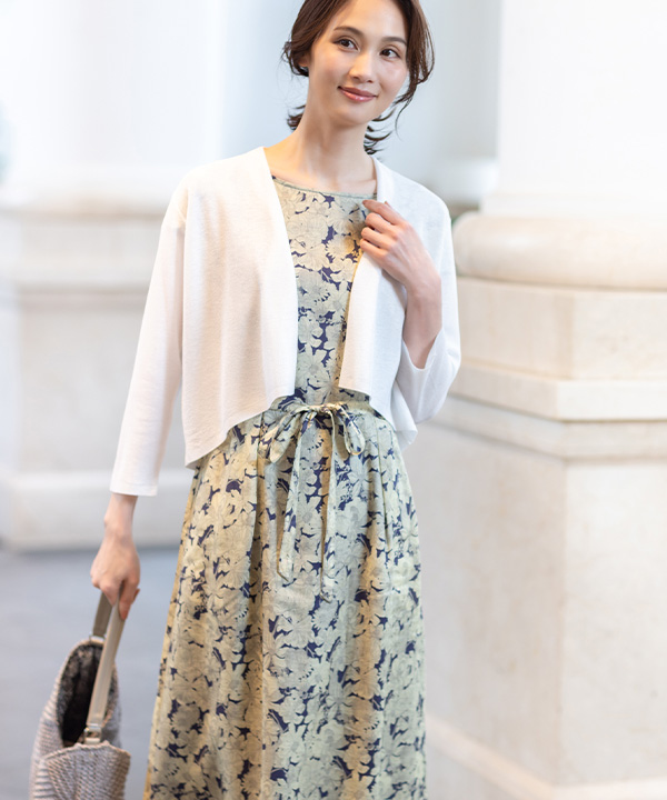 リバティプリントワンピース、ボレロカーディガン、リバティプリントワンショルダーバッグを着用した女性の画像（アンカーリンク）