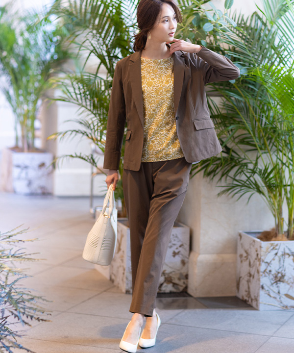 リバティプリントプルオーバー、ストレッチテーラードジャケット、ストレッチストレートパンツを着用した女性の画像（アンカーリンク）