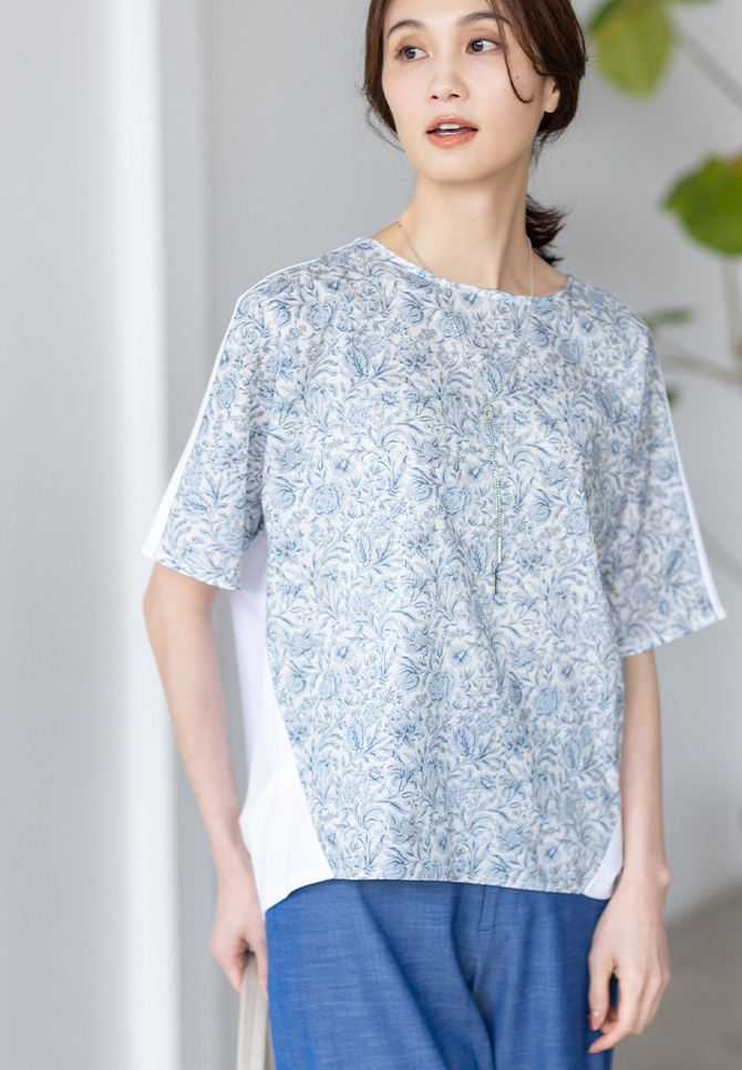 リバティプリントプルオーバー、デニムライクストレッチワイドパンツ、リバティプリントワンショルダーバッグを着用した女性のアップの画像