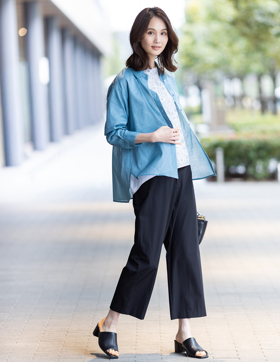 ブラックのストレッチワイドパンツ【接触冷感・後ろウエストゴム】・ブルーのリネンミックスシアーシャツ・ブルーのリバティプリントプルオーバーを着用した女性