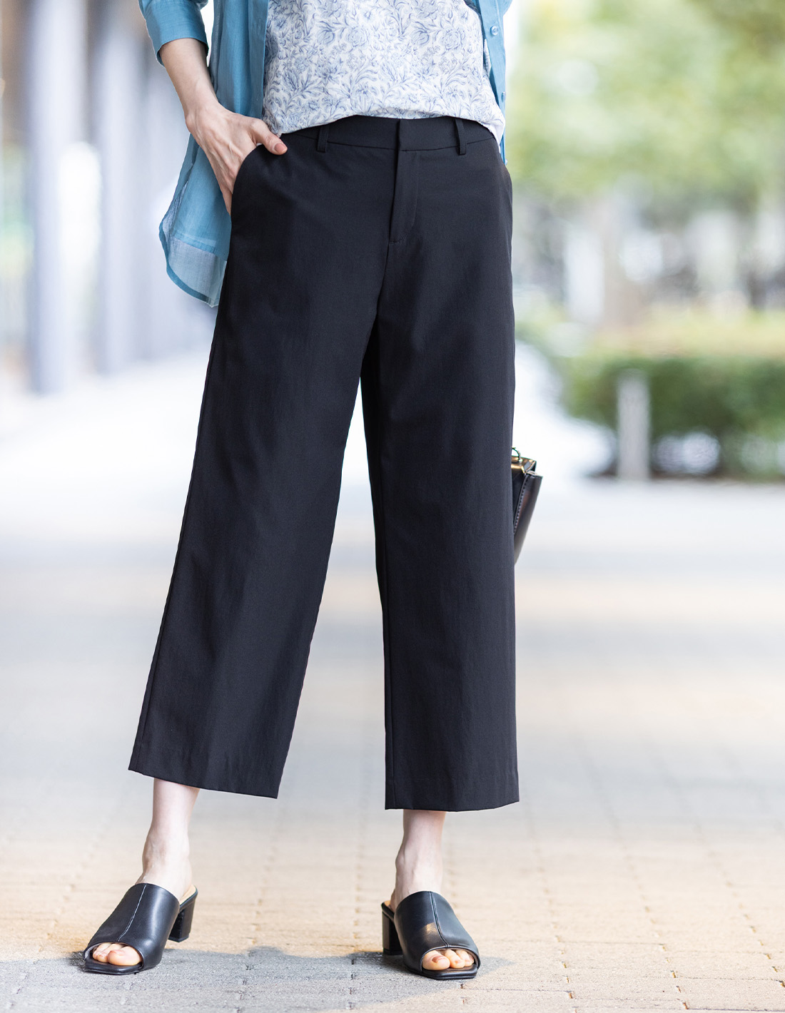 ブラックのストレッチワイドパンツ【接触冷感・後ろウエストゴム】・ブルーのリネンミックスシアーシャツ・ブルーのリバティプリントプルオーバーを着用した女性の足元