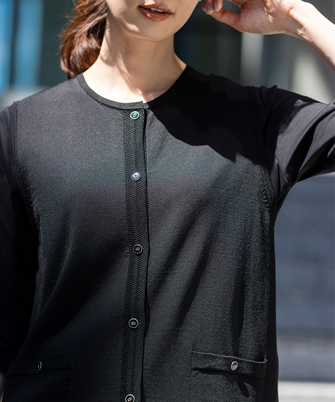 黒色のクルーネックニットベストを着用した女性のアップ画像--1