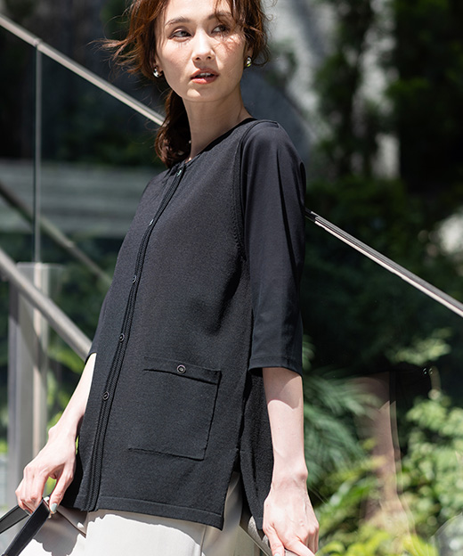 黒色のクルーネックニットベスト、リネンライクセミワイドパンツを着用した女性のアップの画像（ポイント）