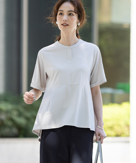 ベージュ色のクルーネックペプラムTシャツ、リネンライクセミワイドパンツを着用した女性の画像（ポイント）
