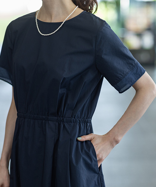 ネイビー色のシアードッキングワンピースを着用した女性のアップの画像（ポイント）
