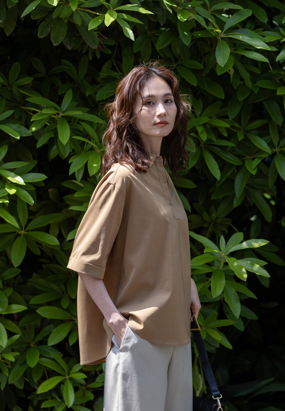 ハーフスリーブスキッパーシャツとリネンライクセミワイドパンツを着用した女性２
