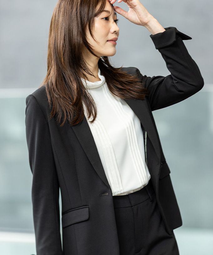 ブラックのテーラードジャケット・白いブラウスを着用した女性のアップ