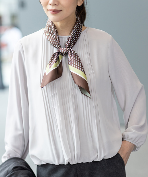 シフォンブラウス・スカーフを首元に巻いた女性のアップ