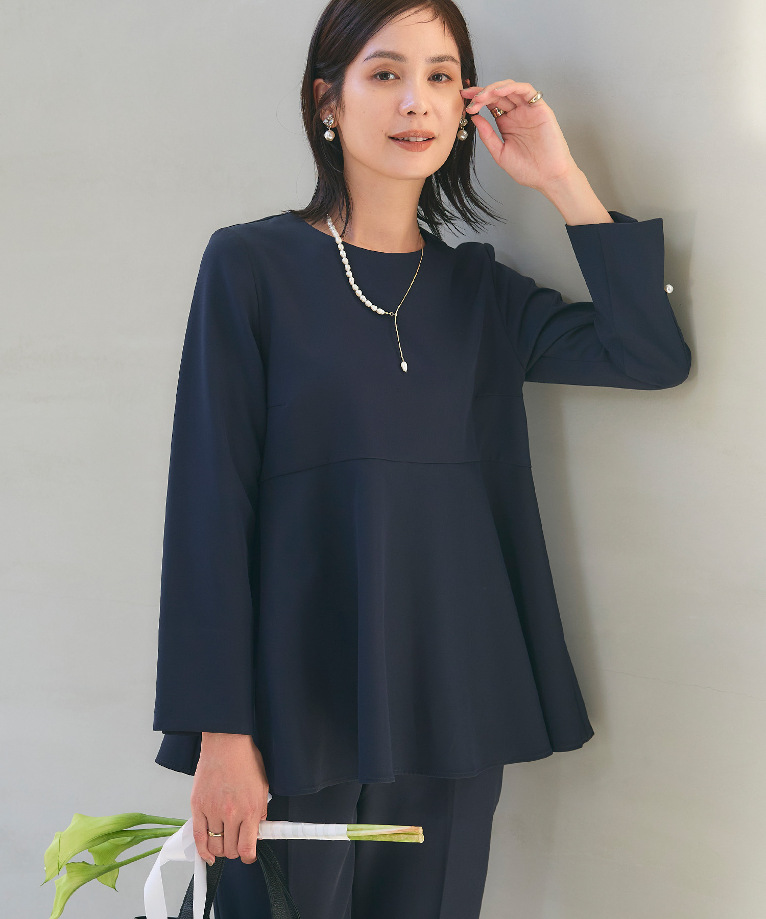 ネイビーの《洗える・シワになりにくい》正解ペプラムブラウス・ネイビーの《洗える・シワになりにくい》正解ワイドパンツを着用した女性の画像（サムネイル）