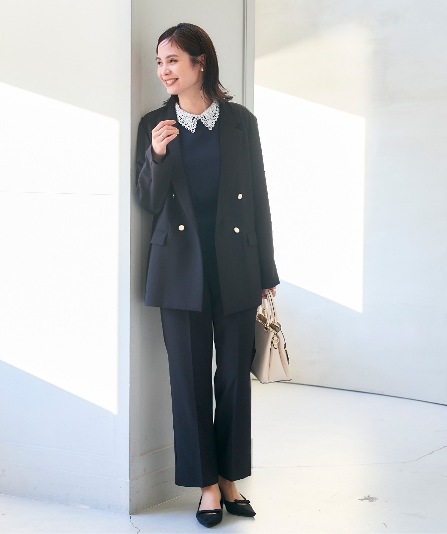 ブラックの《洗える・シワになりにくい》正解 金釦ダブルテーラードジャケット・ブラックの《洗える・シワになりにくい》正解 センタープレスストレートパンツ・ブラックの《洗える》レース襟ニットプルオーバーを着用した女性の画像