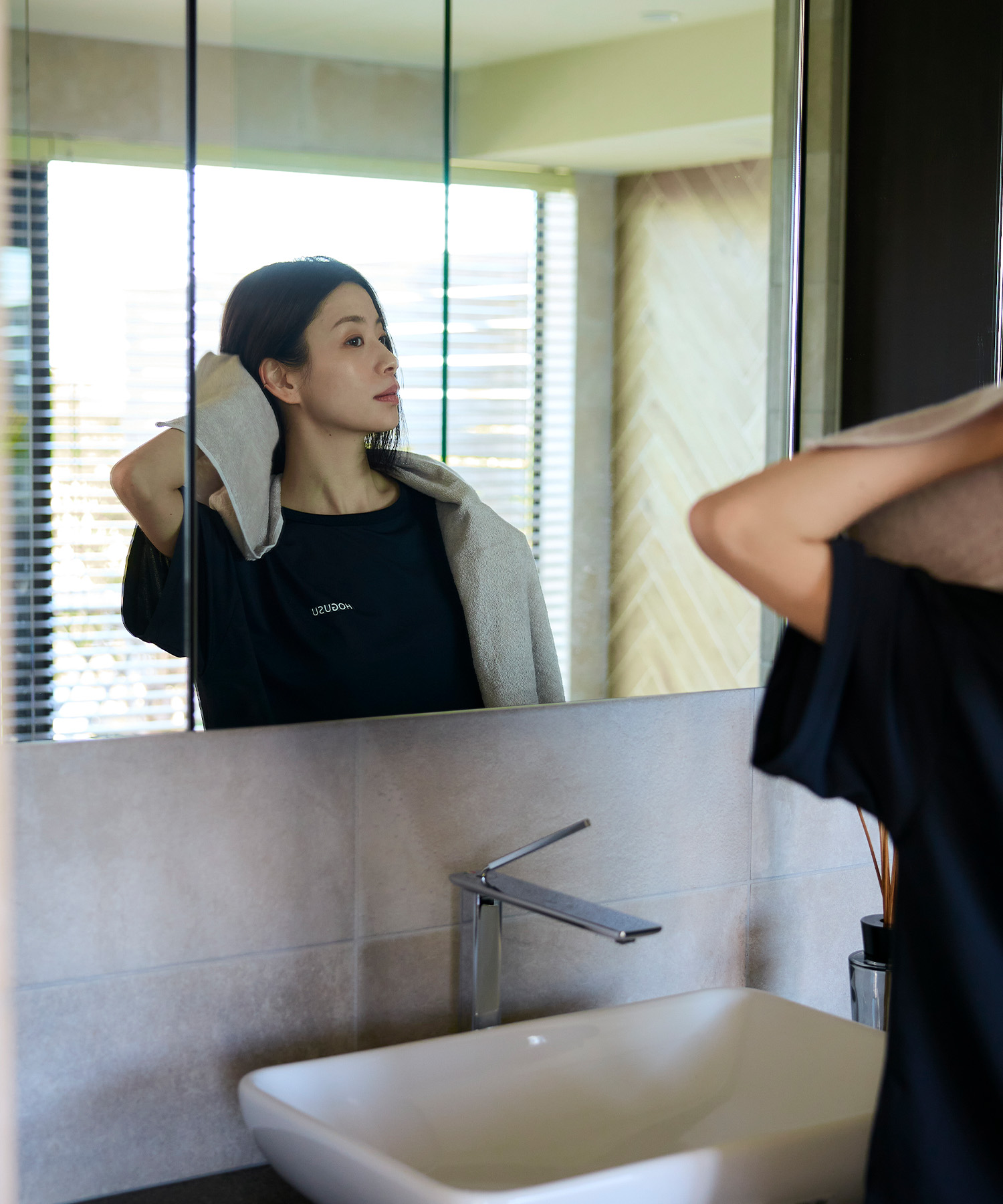 HOGUSUアイテムを着用して鏡を見る女性