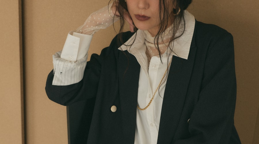 ネイビージャケットと白シャツを着用したモデルの画像