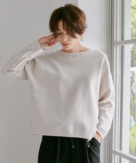 シンプルニットプルオーバーのオフを着用している女性の写真