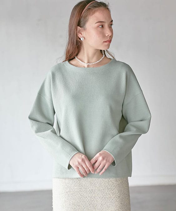 シンプルニットプルオーバーのライトグリーンを着用している女性の写真