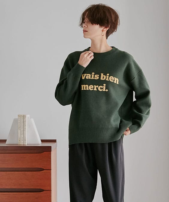 ロゴニットプルオーバーのグリーンを着用している女性の写真