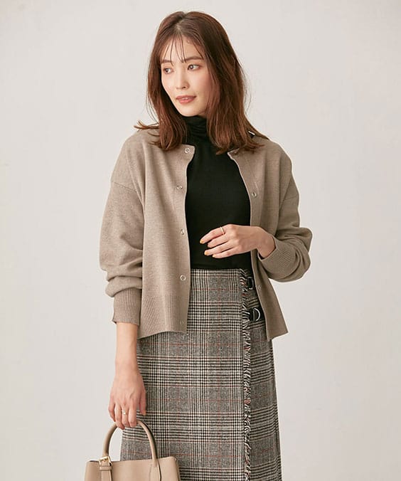 スナップボタンニットカーディガンのモカを着用している女性の写真