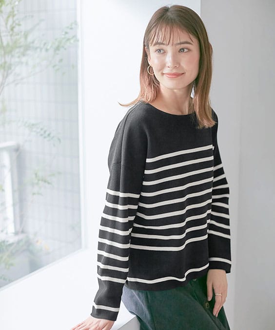 シンプルニットプルオーバーのブラックを着用している女性の写真