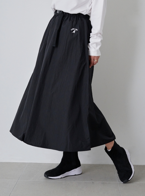 ベルト付きナイロンフレアスカート ブラックを着用した女性の写真