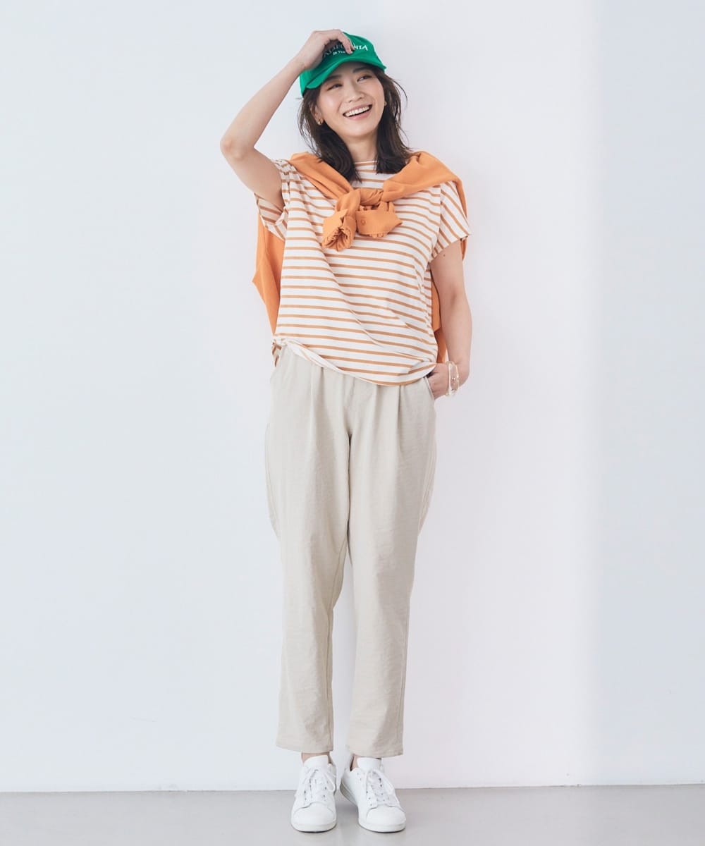 エブ楽／フレンチスリーブTシャツ オレンジ(ボーダー)を着用してキャップを押さえて正面を向いている女性
