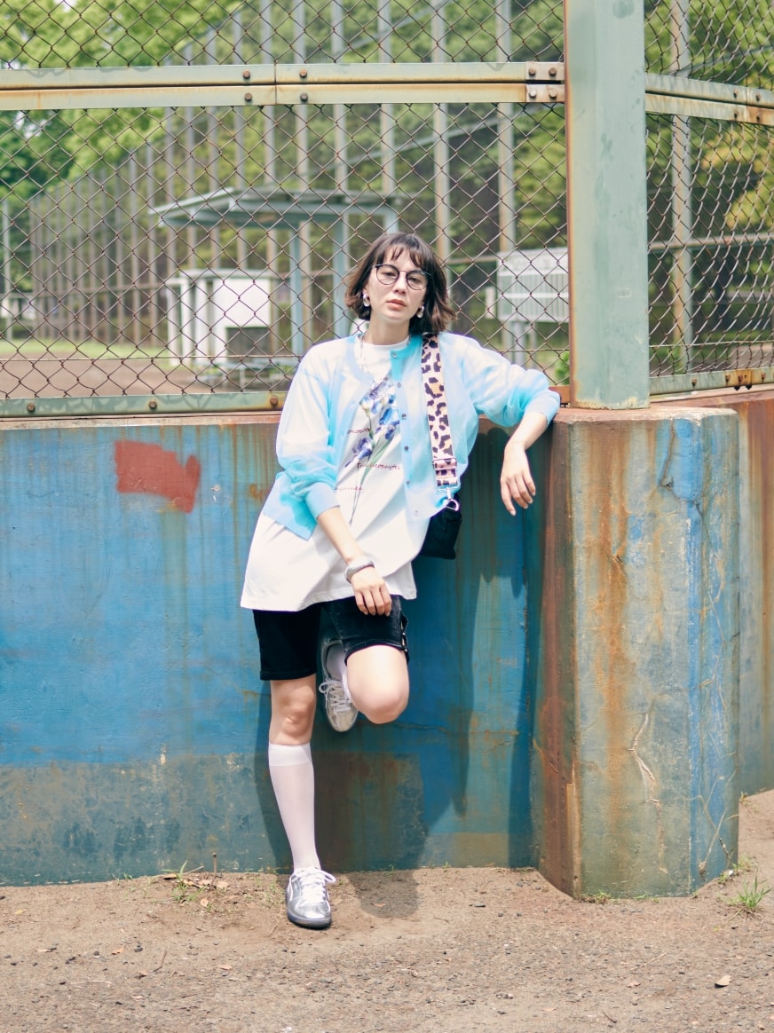 シアーニットカーディガンとアイリスプリントチュニックTシャツとニットハーフレギンスとクラウンバンドサングラスを着用した女性３
