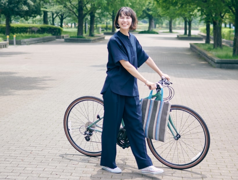 リネンライクシャツ【接触冷感】とリネンライクパンツ【接触冷感】とストライプスクエアトートバッグを着用した女性２