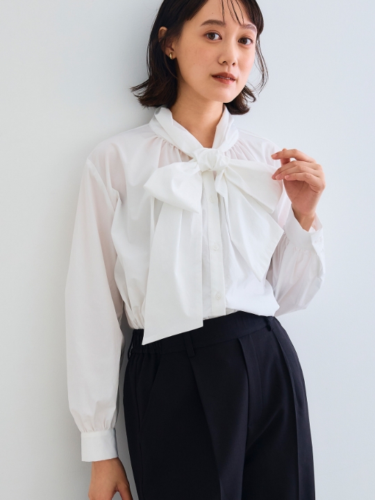 《シワになりにくい》リボンボウタイボリュームシャツを着用した女性